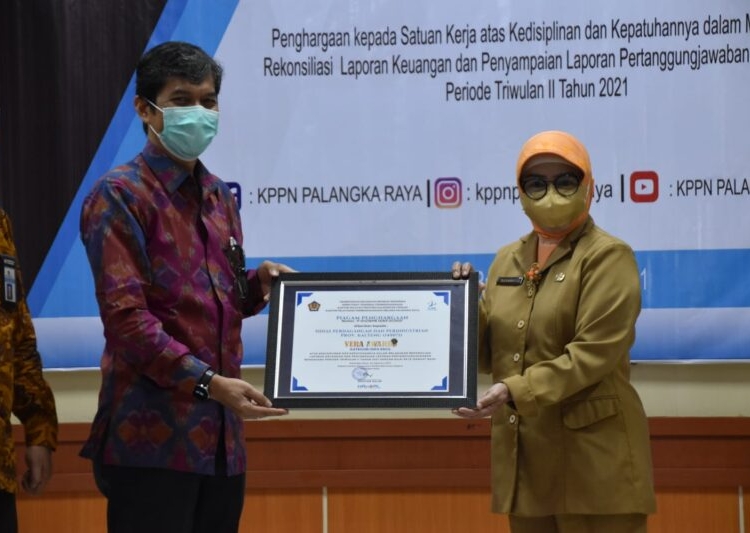 Kepala Disdagperin Prov. Kalteng Aster Bonawaty saat menerima Penghargaan Vera Award Periode Triwulan II Tahun 2021 dari Kepala DJPb Prov. Kalteng Hari Utomo. (Photo/ist)