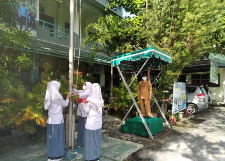 3 Siswi SMA 1 Muhammadiyah Palangka Raya saat melakukan simulasi upacara bendera jelang PTMT. (Photo/ist)