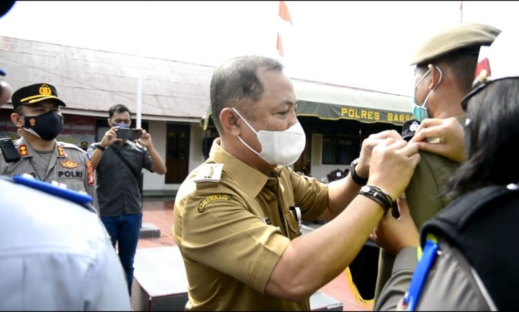 Bupati Barito Selatan, H.Eddy Raya Samsuri menyematkan pita kepada petugas Operasi Patuh Telabang 2021. (Photo/rul)