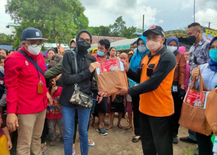 Ketua TP. PKK Prov. Kalteng Ivo Sugianto Sabran menyerahkan bantuan di posko pengungsi warga terdampak banjir di Desa Asam Kumbang, Kecamatan Kamipang, Katingan. (Photo/ist)