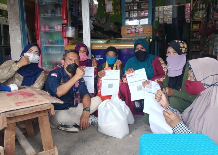 Kepala Dinsos Kapuas Budi Kurniawan, S,sos, Msi bersama warga penerima KPM di Kuala Kapuas dengan menunjukkan sertufikat vaksinasi.