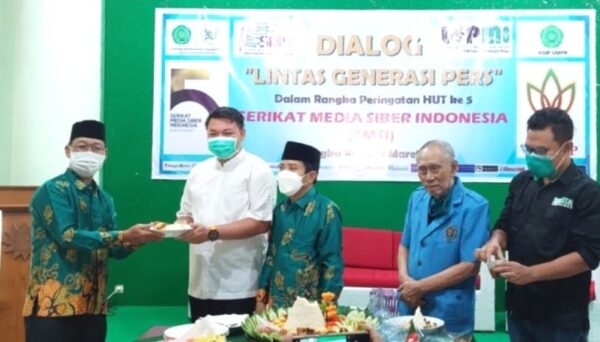 Serahkan Tumpeng-Ketua Pembina SMSI Kalteng H Nor Ivansyah saat menyerahkan nasi tumpeng kepada Heru Hidayat. (IST)