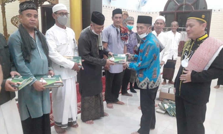 Plt. Kepala Biro Kesra Setda Kalteng Ahmad Fahruka saat menyerahkan bingkisan berupa sarung kepada salah seorang jama’ah Masjid Nurul Hidayah Sukamara. (Photo/ist)