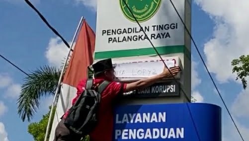 Para pengunjuk rasa juga menutup beberapa slogan pada papan bilboard di depan PT. (IST)