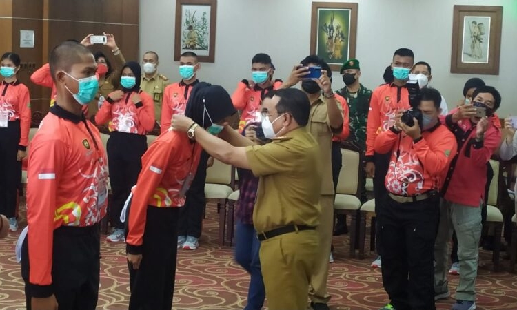 Pengalungan tanda peserta secara simbolis oleh Sekda Prov. Kalteng H. Nuryakin kepada dua orang perwakilan peserta dari Kabupaten Barito Utara dan Kota Palangka Raya. (Photo/ist)