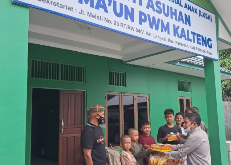 Ketua SMSI Kalteng H. Sutransyah saat menyerahkan bingkisan kepada anak Panti Asuhan Al-Mau'un PWM Kalteng. (Photo/ist)