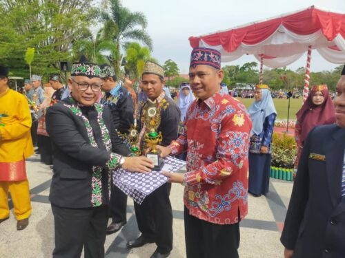 Kakanwil Kemenag Kalteng H. Nor Fahmi memberikan tropy dan piagam penghargaan kepada juara favorit anugerah GTK berprestasi Nasional H. Rus'ansyah pada apel HAB Kemenag Kalteng. (Photo/ist)