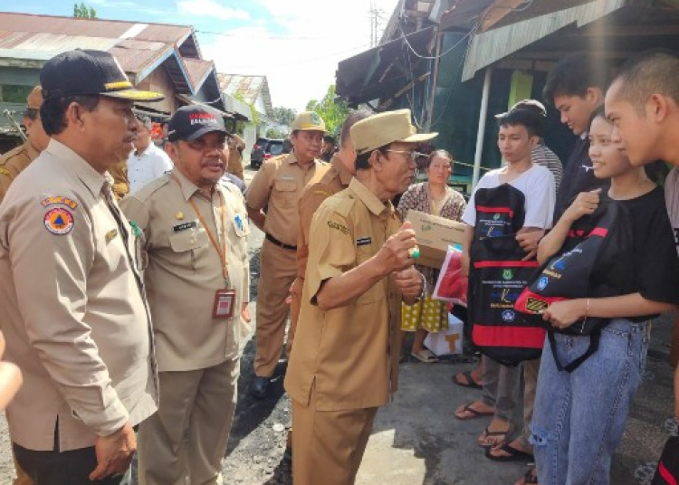 Pelaksana Tugas Bupati Kapuas Drs. H. Nafiah Ibnor di dampingi Sekda Kabupaten Kapuas Drs. Septedy saat menyerahkan bantuan. (Ist)