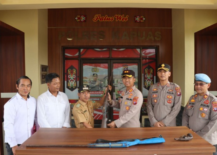 Warga Tumbang Mangkutup saat menyerahkan senpi rakitan ke Polres Kapuas. (ist)