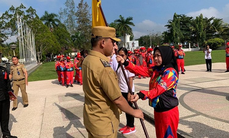 Pj. Bupati Barito Selatan Deddy Winarwan menyerahkan Pataka Barsel kepada Ketua KONI Kab. Barsel Ida Riani