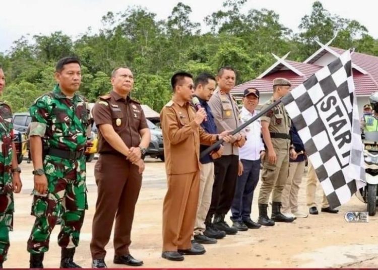 Pj. Bupati Murung Raya Hermon mengibarkan bendera start tanda pelepasan Patroli Gabungan Skala Besar jelang Pemilu 2024. (Photo/rosa)