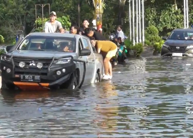 Kendaraan roda 4 terpaksa harus hati-hati saat melintasi jalan yang tergenang banjir. (Photo/niswa)