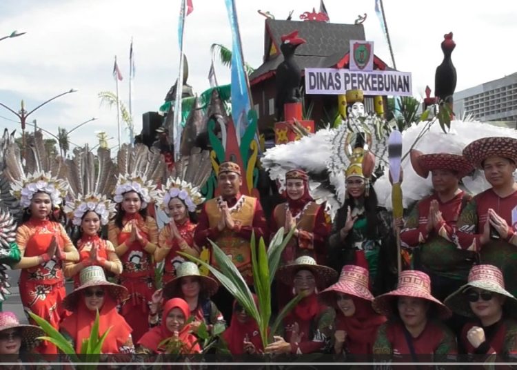 Peserta Karnaval FBIM Dinas Perkebunan Kalteng photo bersama dengan latar belakang mobil hias yang menonjolkan produk unggulan Kalteng.(Photo/ivan)