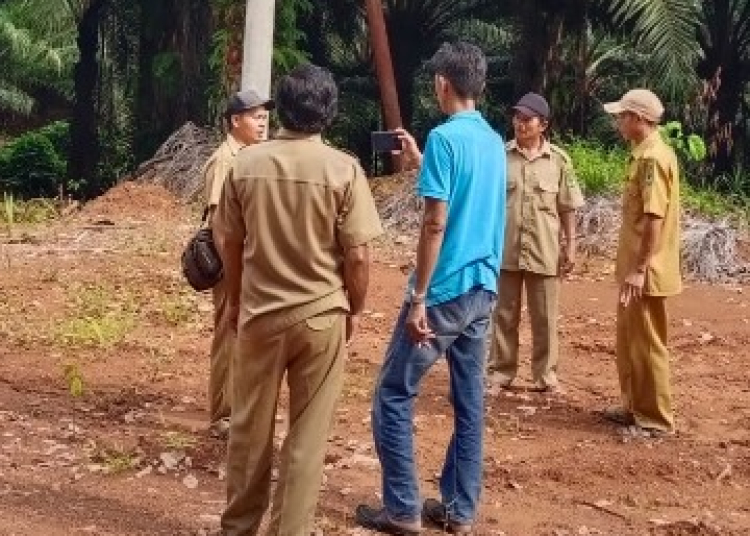 Aprat  desa  Tumbang Puroh Kecamatan Kapuas Hulu Kabupaten Kapuas saat menunjukkan lokasi tiang listrik yang diklaim berada di jalan perusahaan..(Foto: Ucok Nasution)