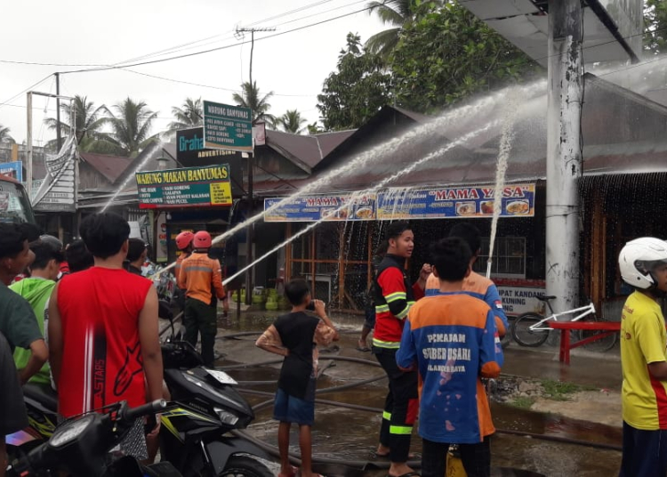 Keterangan Foto : Petugas damkar saat melakukan upaya pemadaman dan pendinginan dilokasi kebakaran. FOTO/RIZAL