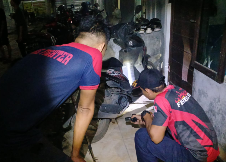 KETERANGAN FOTO : Petugas Damkar mengeluarkan ular yang bersembunyi di sepeda motor milik penghuni kost di Jalan G.obos 7, Kota Palangka Raya. FOTO/RIZAL