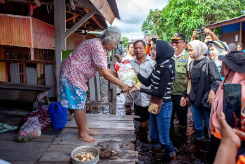 Ketua TP PKK Kalteng, Aisyah Thisia Agustiar Sabran saat menyerahkan bantuan beras kepada salah seorang warga terdampak banjir.(Photo/ad)